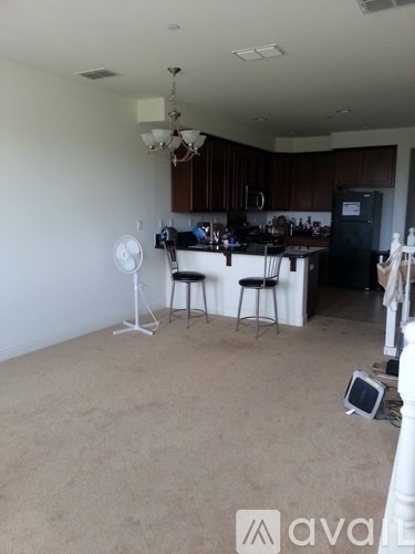 A kitchen with a fan and a dining table.