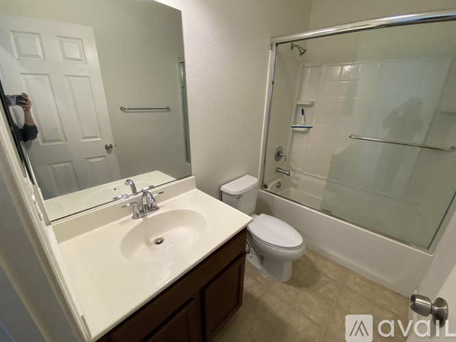 A bathroom with a sink, toilet, and shower.