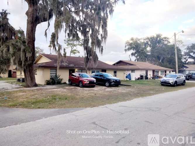 A row of houses with cars parked in front.