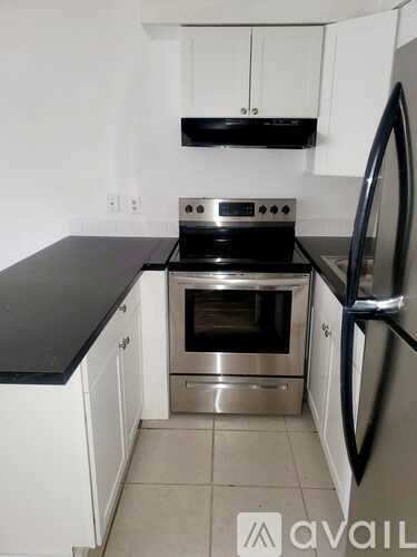 A kitchen with a stove top oven and a refrigerator.