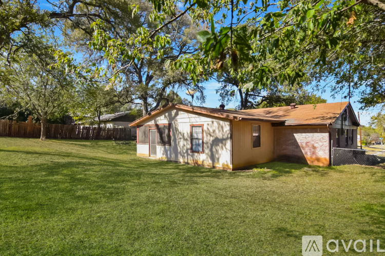 A house with a brown roof is surrounded by trees.