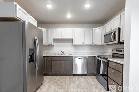 A modern kitchen with a refrigerator, sink, and stove.