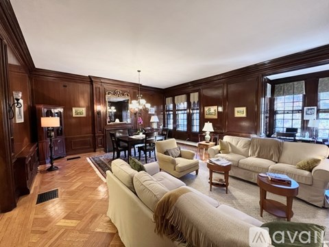 A living room with a white couch and wooden floors.