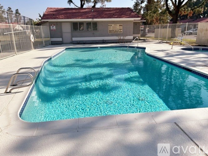 A small pool in a backyard with a house in the background.