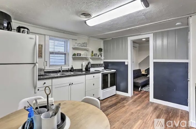 A kitchen with white cabinets and a wooden table.
