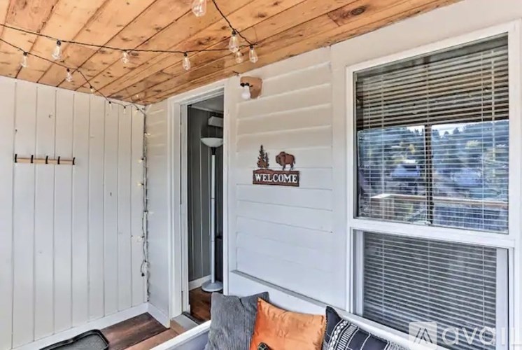 A cozy living room with a couch and a welcome sign on the wall.