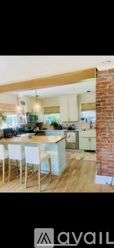 A kitchen with white chairs and a wooden table.