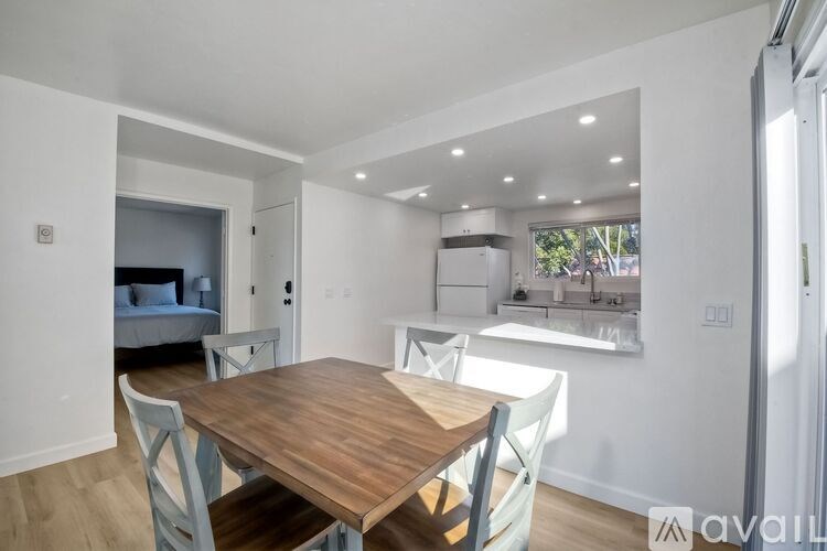A dining room with a wooden table and chairs.