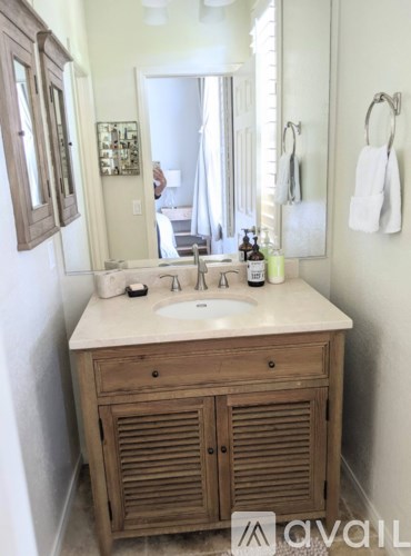 A bathroom with a wooden vanity and a mirror.