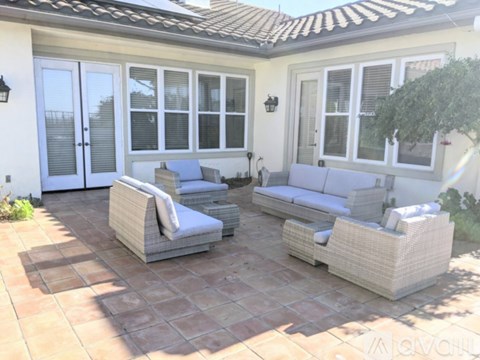A patio with a couch, chair, and table.