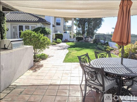 A patio with a table and chairs under a canopy.
