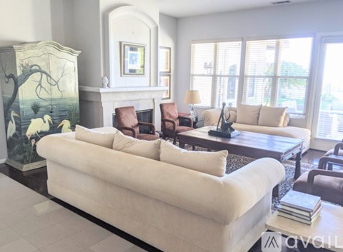A living room with a white couch and a fireplace.