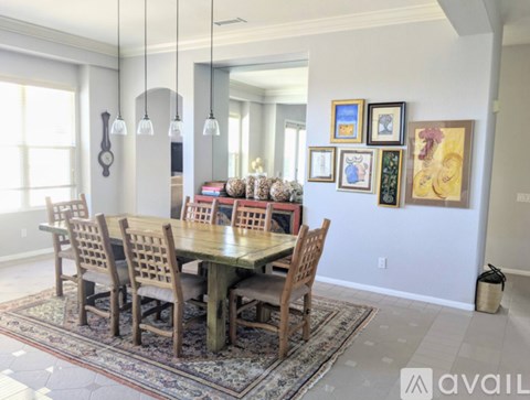 A dining room with a table and chairs.