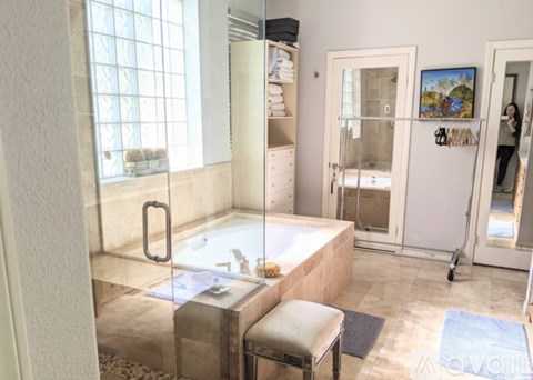 A bathroom with a tub and a chair.
