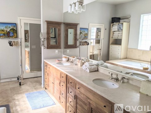 A bathroom with a double sink vanity and a large mirror.