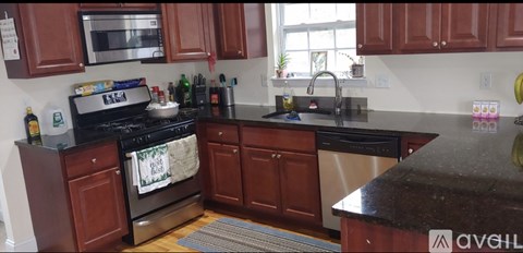 A kitchen with brown cabinets and black appliances.