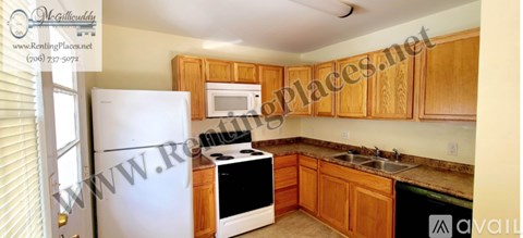A kitchen with wooden cabinets and a white refrigerator.
