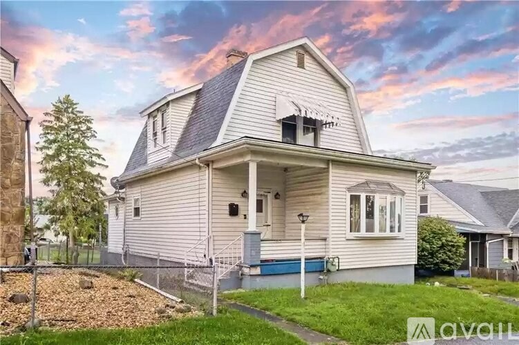 A two-story house with a front porch and a garage door.