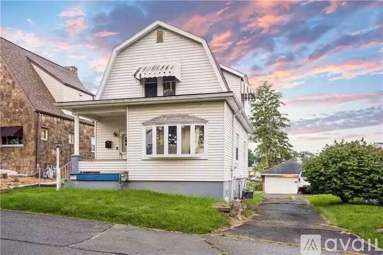 A house with a porch and a covered walkway leading to the front door.
