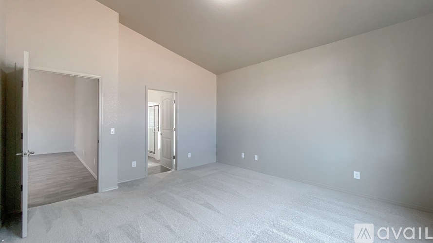 A spacious empty room with a door on the left and a door on the right.