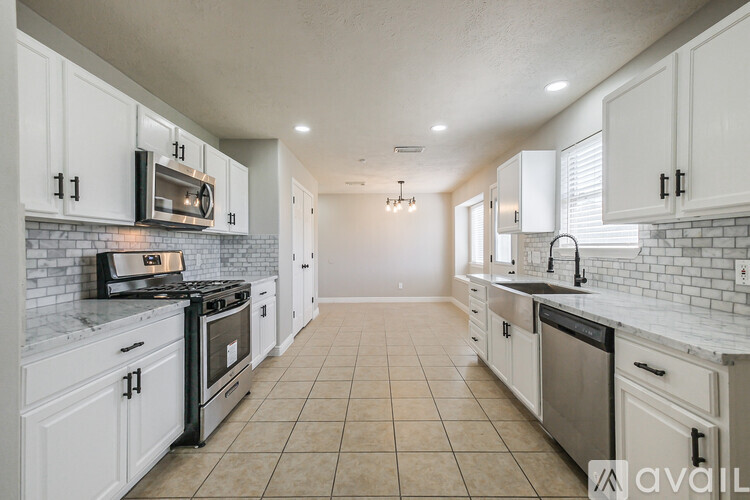 A kitchen with white cabinets and appliances.