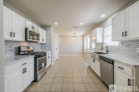 A kitchen with white cabinets and appliances.