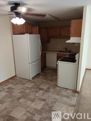 A kitchen with a white refrigerator and a white dishwasher.