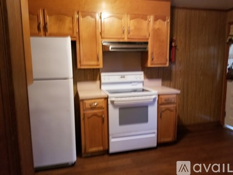 A kitchen with wooden cabinets and a white fridge.