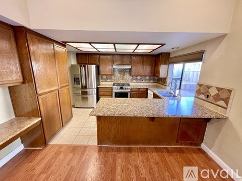 A kitchen with wooden cabinets and a granite countertop.