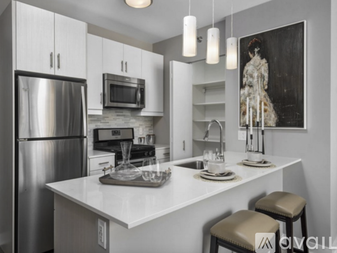 A modern kitchen with a large island and stainless steel appliances.