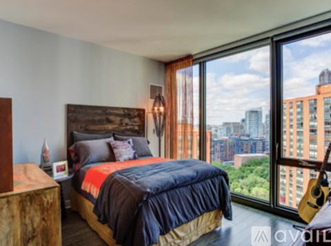A bedroom with a large bed and a view of the city.