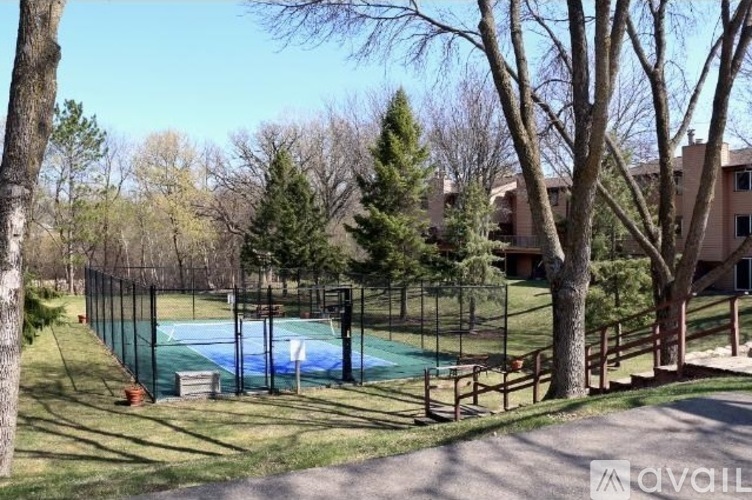 A pool surrounded by trees and a fence.
