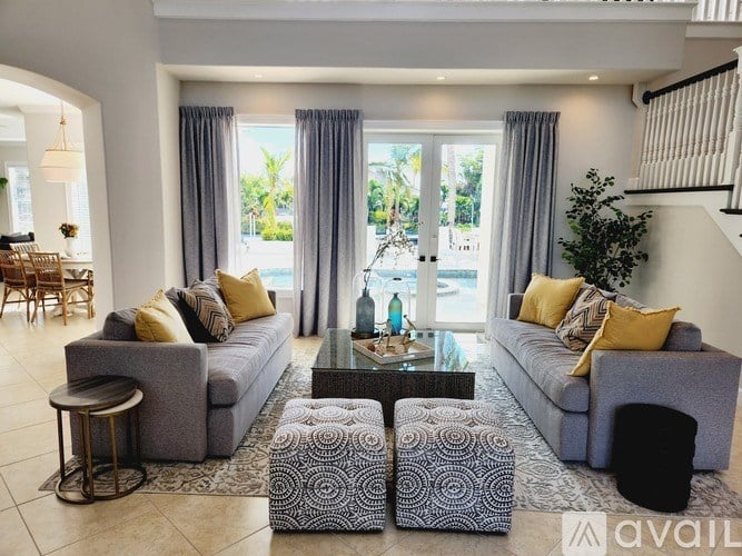 A living room with grey couches and a glass coffee table.