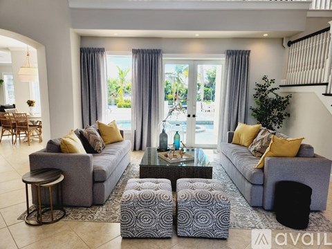 A living room with grey couches and a glass coffee table.