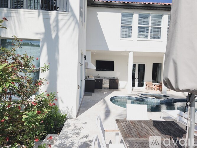 A white house with a pool in the backyard.