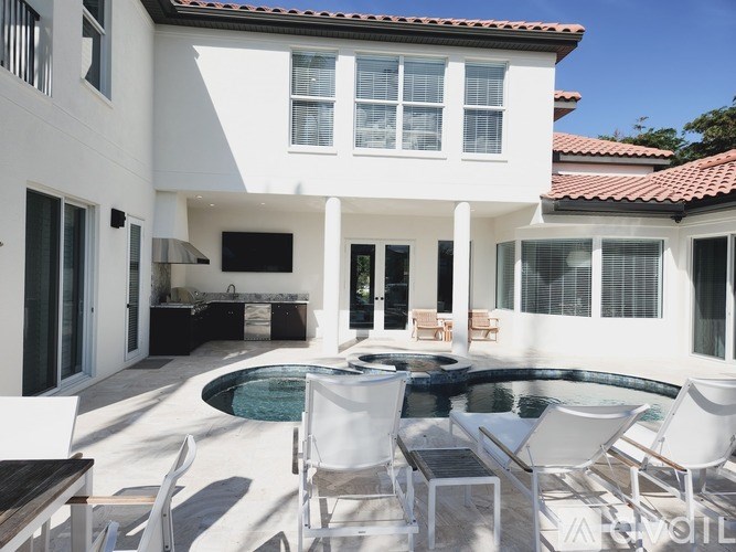 A white house with a pool in the backyard.