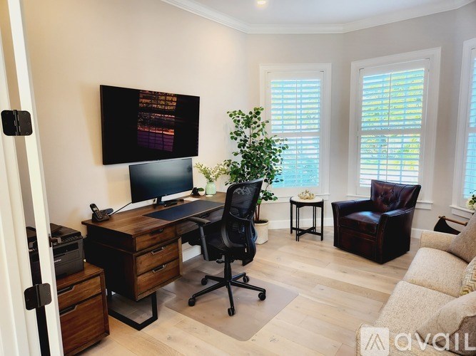A home office with a desk, chair, and computer monitor.