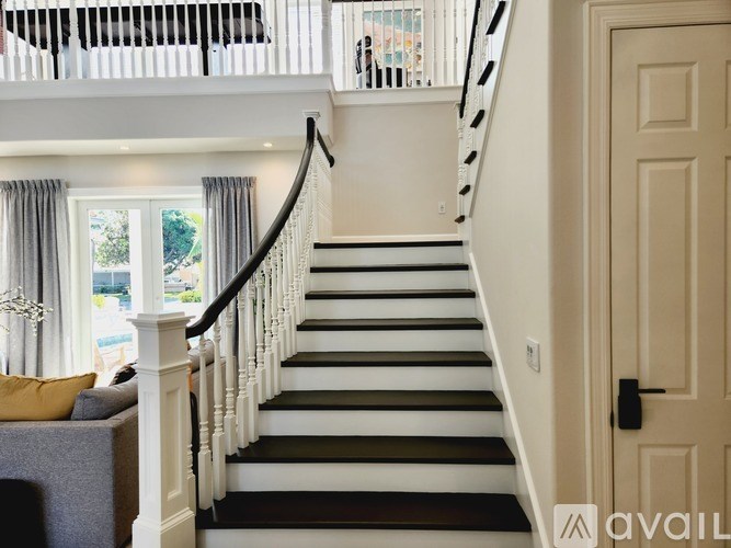 A staircase with black and white steps and a white railing.