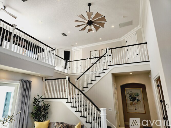 A living room with a staircase and a plant.