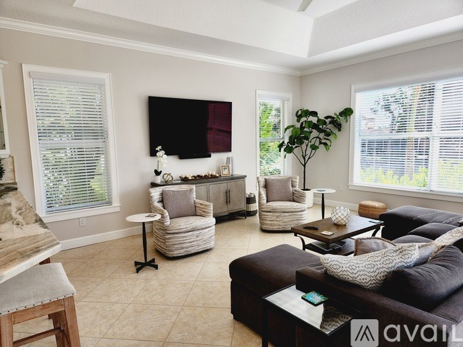 A living room with a large couch, a chair, and a table.