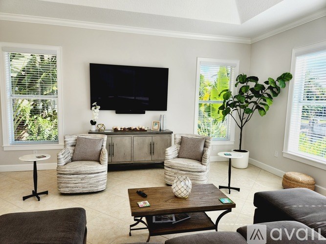 A living room with a flat screen TV mounted on the wall.