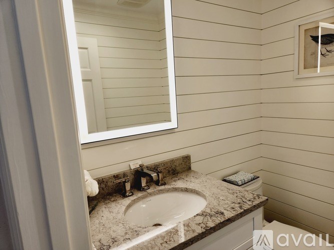 A bathroom with a marble countertop and a round sink.