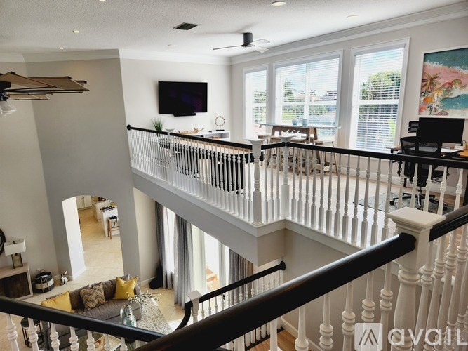 A living room with a balcony and a television.