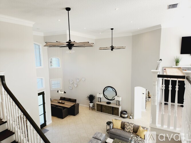 A living room with a staircase on the left and a couch in the center.