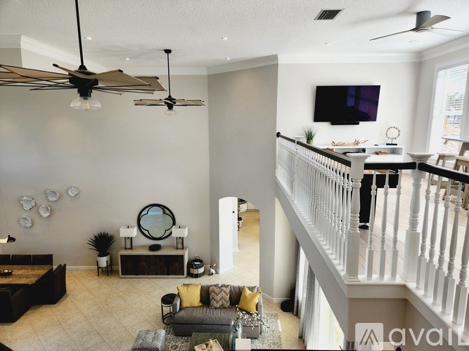 A living room with a white railing and a television on the wall.