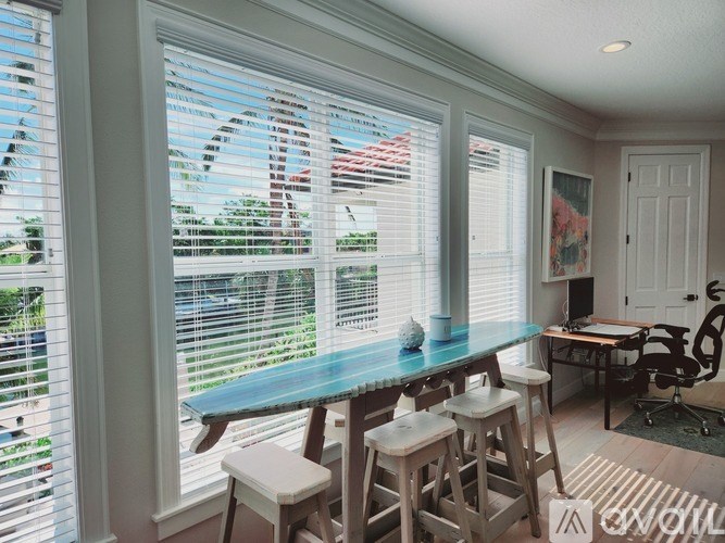 A dining room with a table and chairs by the window.
