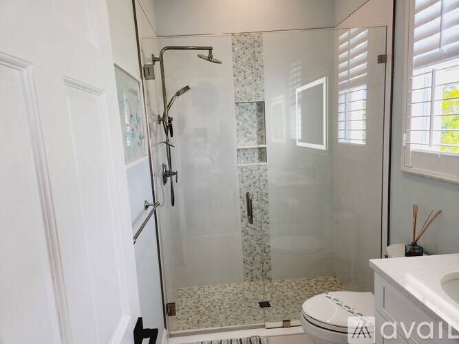 A bathroom with a toilet, sink, and shower.