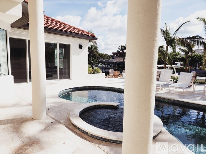 A white house with a pool in the backyard.