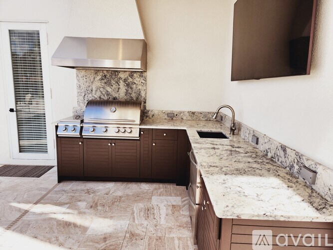 A kitchen with a stone backsplash and a marble countertop.