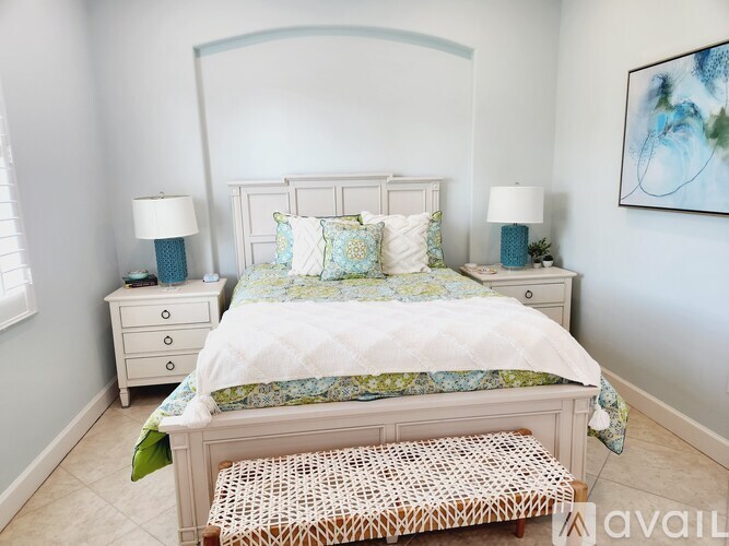 A bedroom with a large bed and two nightstands with lamps.